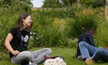 Two students sat in the grounds of the Botanic Garden